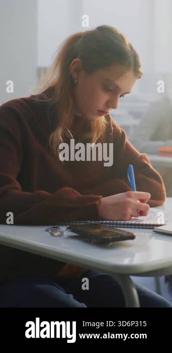Sad Teenage Girl Sits Alone at Desk, Looking Down Notebook While ...