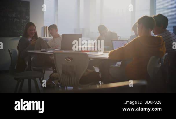 Diverse Group of Students Gathers Around Central Table, Working ...