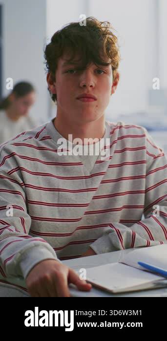 Young Student in Striped Sweatshirt With Focused Expression Sits Desk ...