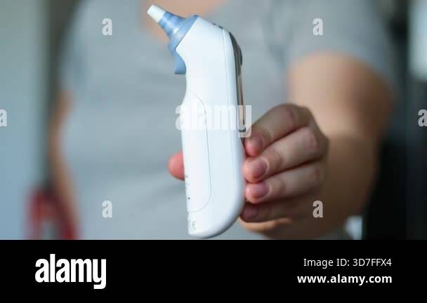Close up of a female holding a modern digital fever thermometer ...