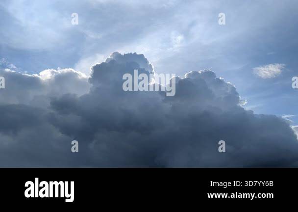 A dramatic sky with heavy, dark clouds looms over the dark silhouettes ...