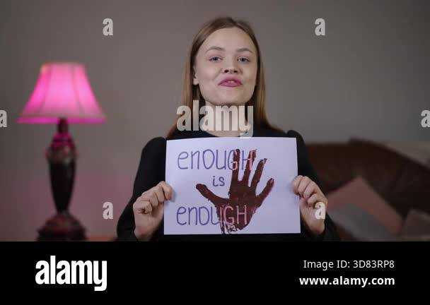 White woman holds enough is enough sign with red handprint, assertive ...