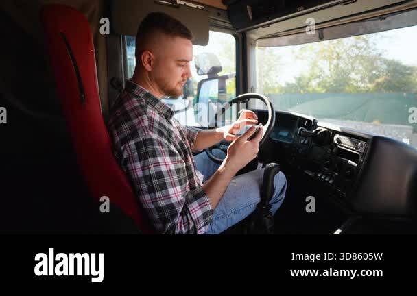 Professional male truck driver sitting behind the wheel in his semi ...