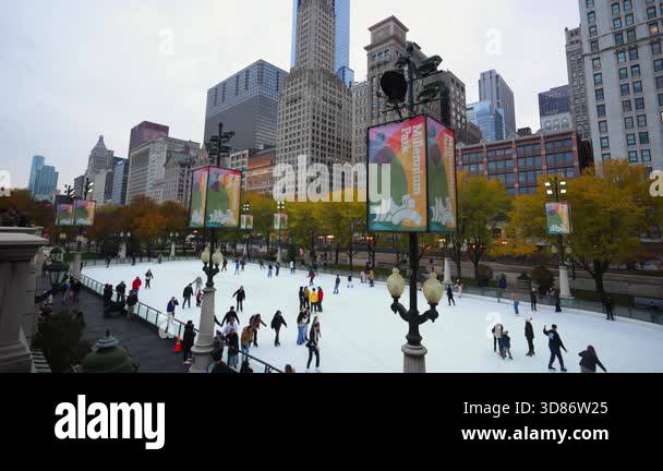 People skating on an outdoor ice rink in downtown Chicago on cloudy ...
