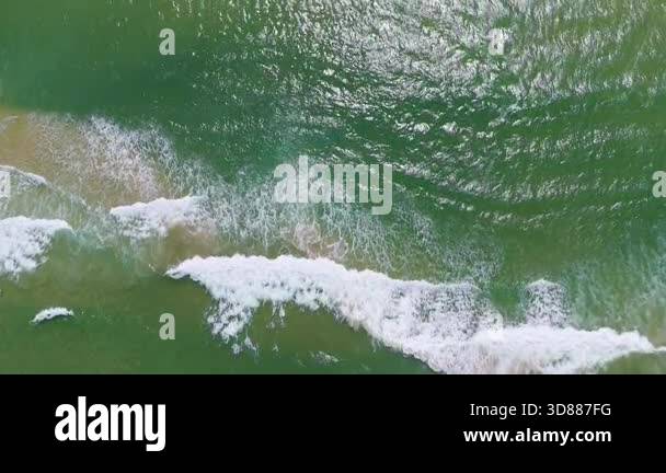 Drone captures waves crashing on sandy shore Stock Video Footage - Alamy