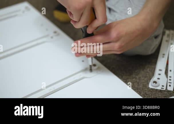 Adjusting drawer rail on side panel during dresser assembling ...