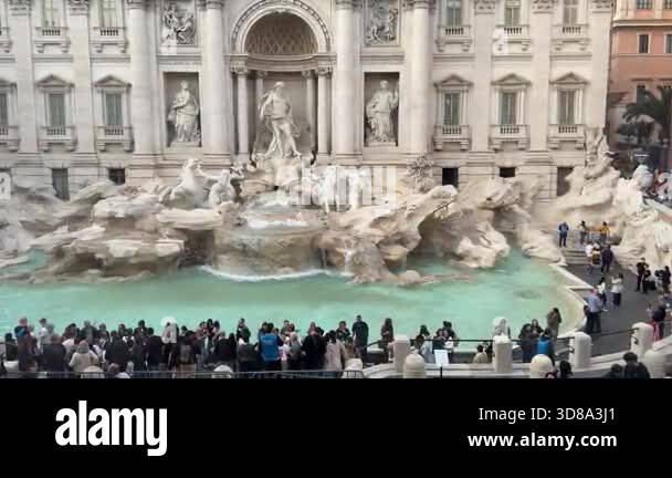 Tourists standing in busy crowd near Trevi Fountain in Rome waiting in ...