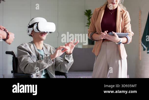 Man in wheelchair wearing VR headset exploring interface, colleagues ...