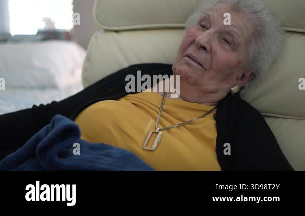 Elderly woman relaxes in her chair at a healthcare facility, capturing ...