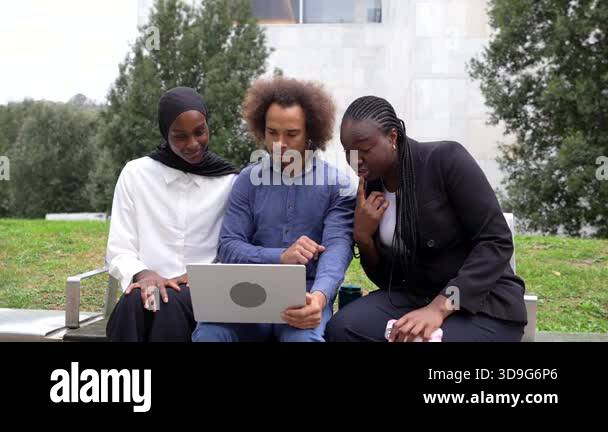 Multi ethnic group of three young coworkers collaborating on a business ...