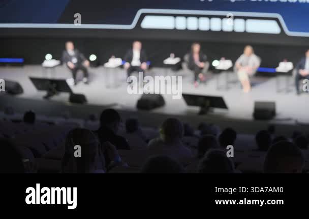 Panel discussion on stage with professionals seated in conference ...
