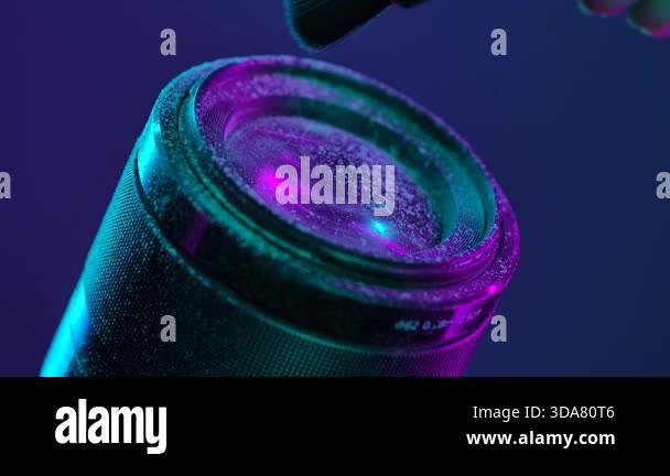A close up of a camera lens being cleaned with a brush to remove dust ...