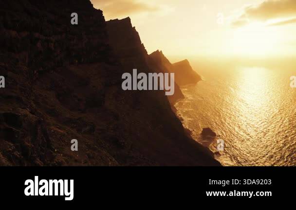 Dramatic sunset over the rugged cliffs of Gran Canaria, Spain, casting ...