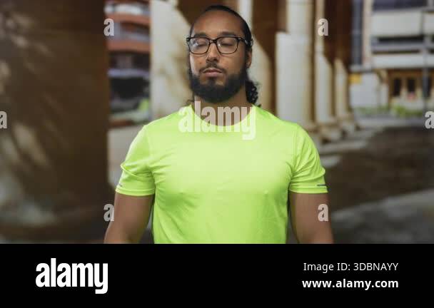 Man with hand on forehead and closed eyes in front of building columns ...