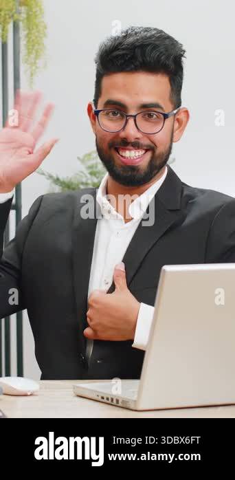 Hello. Indian business man working on laptop computer smiling friendly ...