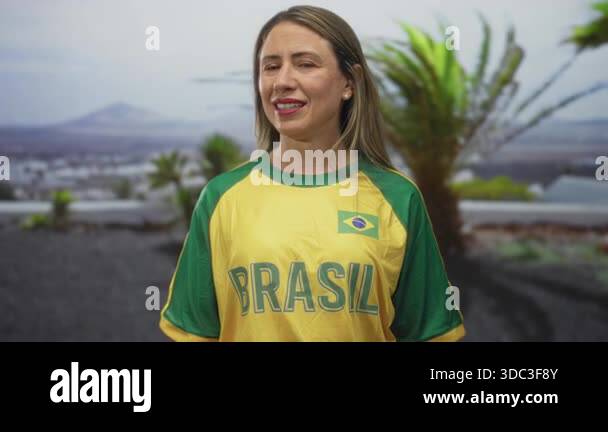 Woman wearing brazilian jersey points thumb to shirt and shushing ...