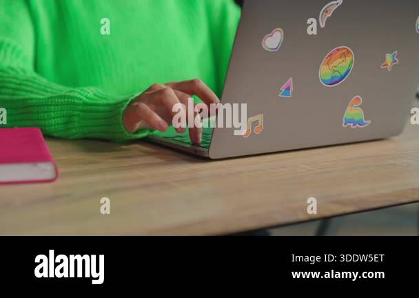 Female hands typing on keyboard of laptop with lgbt rainbow stickers in ...