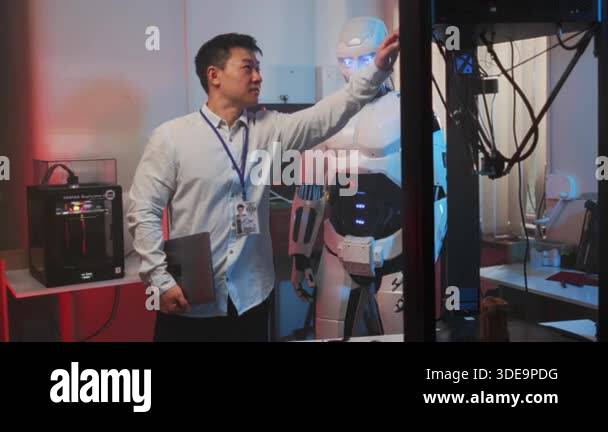 Asian engineer performs handshake test humanoid robot in bright lab ...