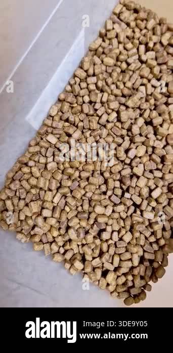 High-angle macro shot of a large pile of dry dog or cat food. The ...