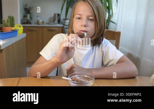 Child Eating Routine Child eating and drinking at home table. Calm everyday moment of a kid ...