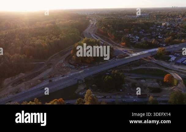 Aerial highway overpass construction with curved ramps at golden hour ...
