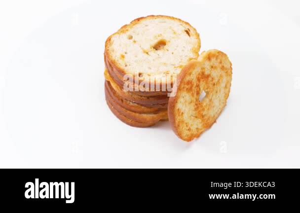 A top view of stacked baked bread slices rotates gently in a clean ...
