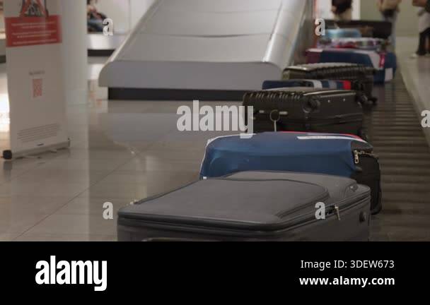 Suitcases traveling on conveyor belt at airport baggage claim area ...