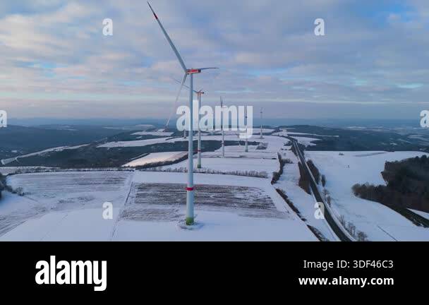Windless wind turbine in snow, dark doldrums or wind lull in winter ...