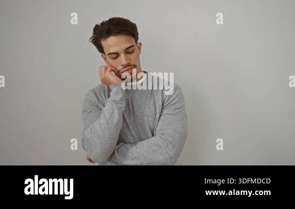 Young man with facial hair in gray sweater standing against white ...