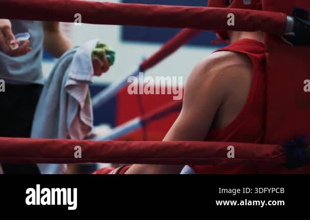 Boxing tournament. The athlete is resting between rounds. Coach giving ...