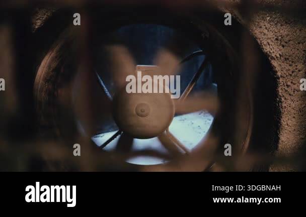 Close up of an industrial ventilation fan spinning inside a concrete ...