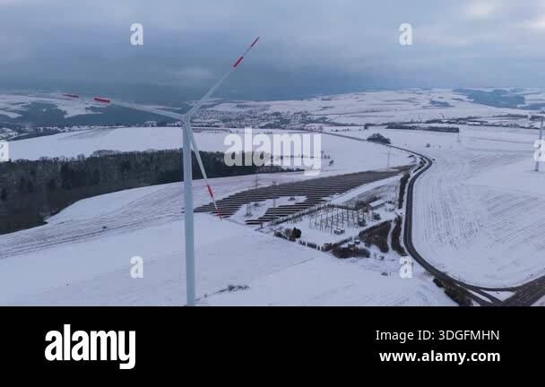 Wind turbine and solar panel in snow, dark doldrums or wind lull in ...