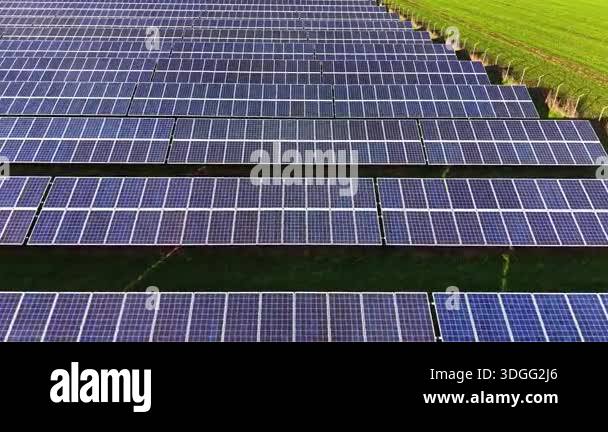 Large solar panel array set in a green field captures sunlight for ...