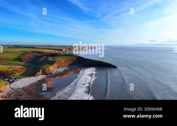 Spectacular green rocky shore of the sea. Waves slowly move to the ...