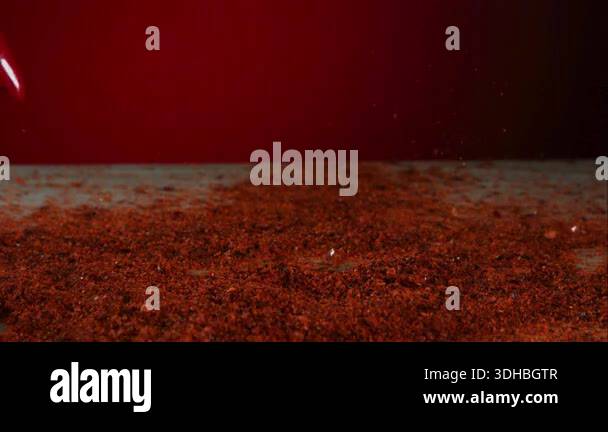 Red Chili Pepper Falling and Bouncing on a Bed of Ground Paprika Spice ...