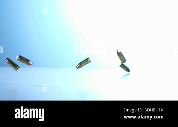Brass bullet casings falling and bouncing on a white clinical surface ...