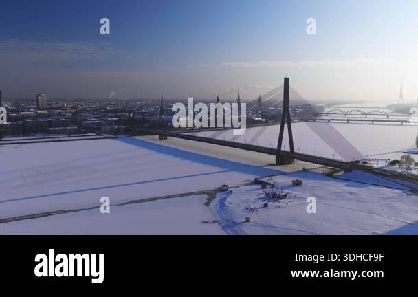Aerial 4K view of Vansu Bridge spanning frozen Daugava in Riga, Latvia ...