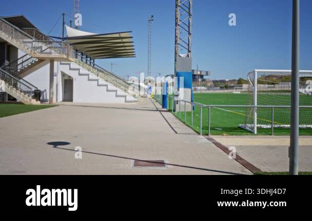 Football pitch with soft shallow blur and out of focus sideline stands ...