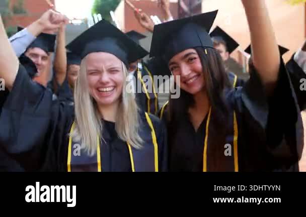 Group of excited multiracial students in graduation gowns and ...