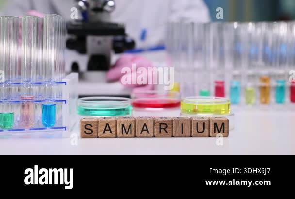 Chemist adjusts microscope controls to improve clarity. Wooden letter ...