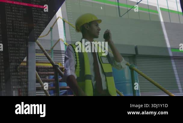 Engineer speaking into radio and scanning warehouse activating code ...
