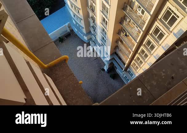 View down from top floor of multi-story building. Facade of white multi ...