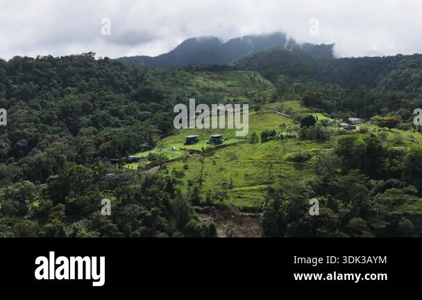 Lush green landscape of a remote village nestled in the misty mountains ...