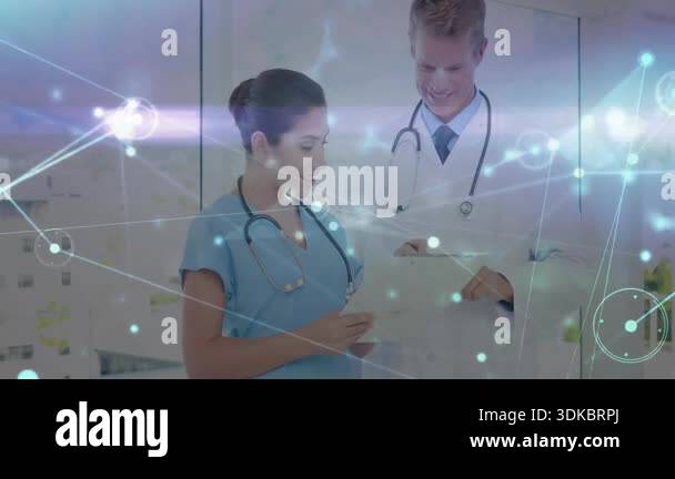 Doctor tapping tablet and guiding nurse through network overlay data ...