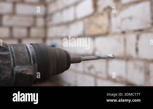 Close-up of a powerful electric drill with a spinning drill bit ...