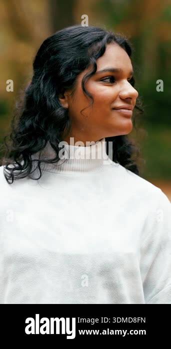 Serene portrait of a beautiful young indian woman with long curly hair ...
