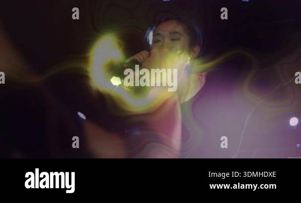 Female singer raising microphone singing under stage lights with neon ...