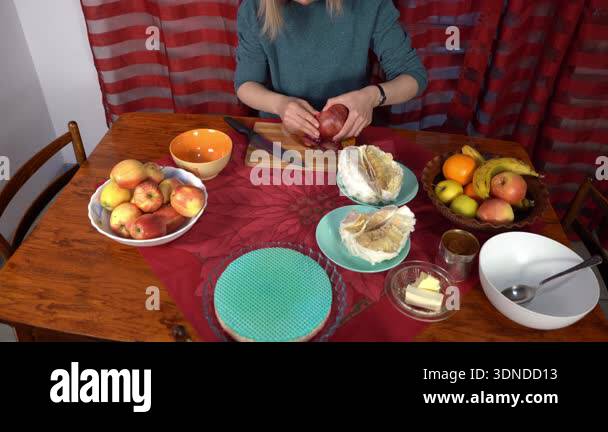Woman peeling red pomegranate with her hands. Fruits on the table ...