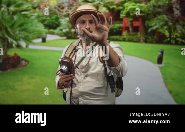 Man with vintage camera and reaching hand on forest path, backpack and ...