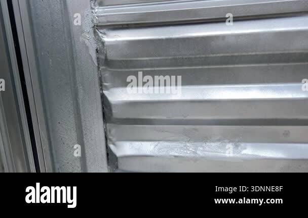 Window Cell Inside Macro view of a welded seam and caulking inside a corrugated metal ...